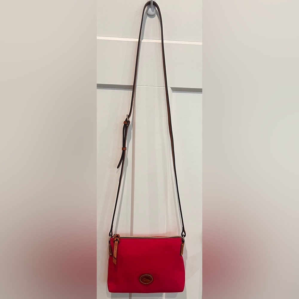 Dooney & Bourke cross body in pink nylon with leather strap, pull and trim.